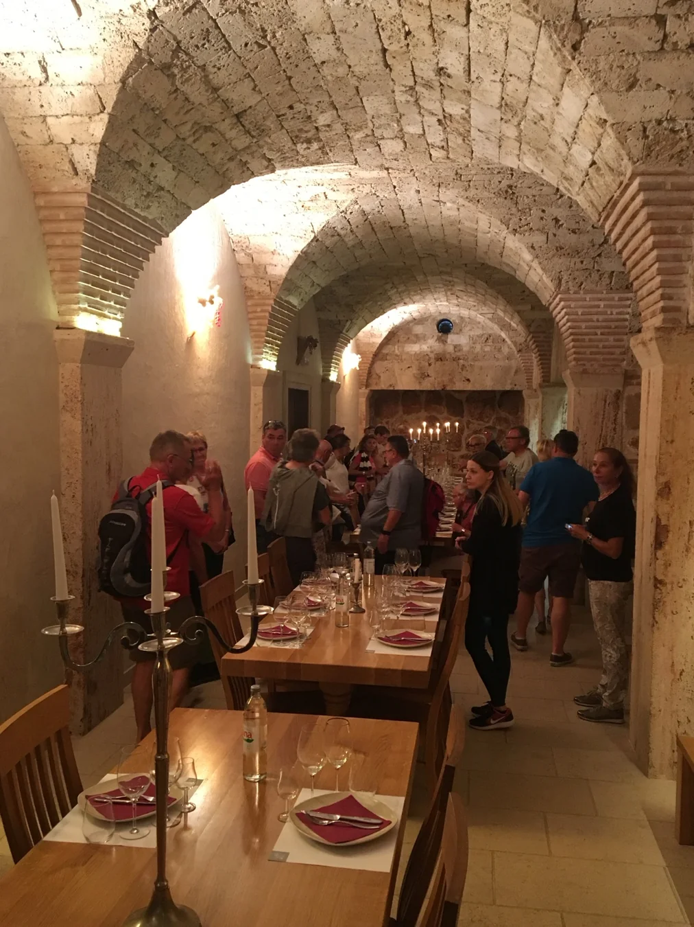 Guests gathered for a winery tasting in a brick cellar